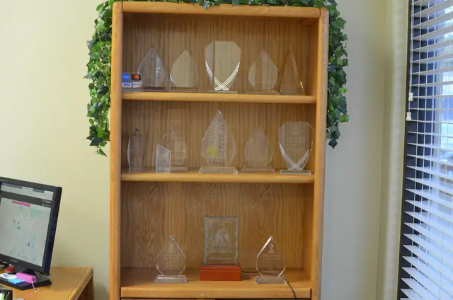 The award shelf in the Reid's office, holding BBB Awards for Excellence plaques and a Dave Lennox dealer award